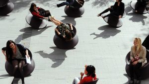 people sitting in sculptural black chairs