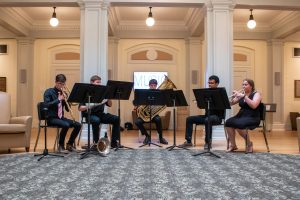a group of brass players perform in the Hill Hall rotunda