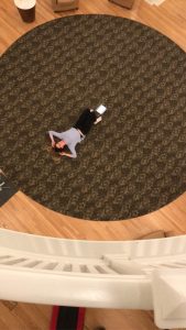 a girl laying on a round carpet. image taken from above