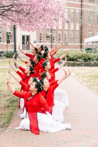 members of lying silk pose for photos outside on UNC's campus