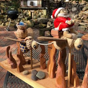 wooden sculpture of bumble bees and santa claus