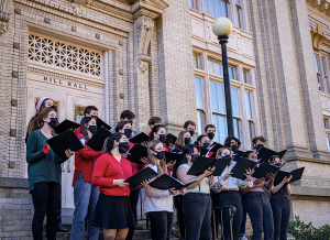 The Carolina Chamber Singers stand in formation as they sing carols on the steps of Hill Hall