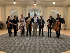 The cast and musicians of Intimate Economies take their bow after the premiere in the Hill Hall rotunda