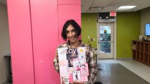 Rohan holds up a collage that he created in Morrison Art Studio