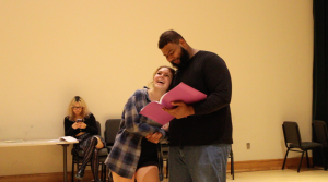 Two people acting while reading from the script